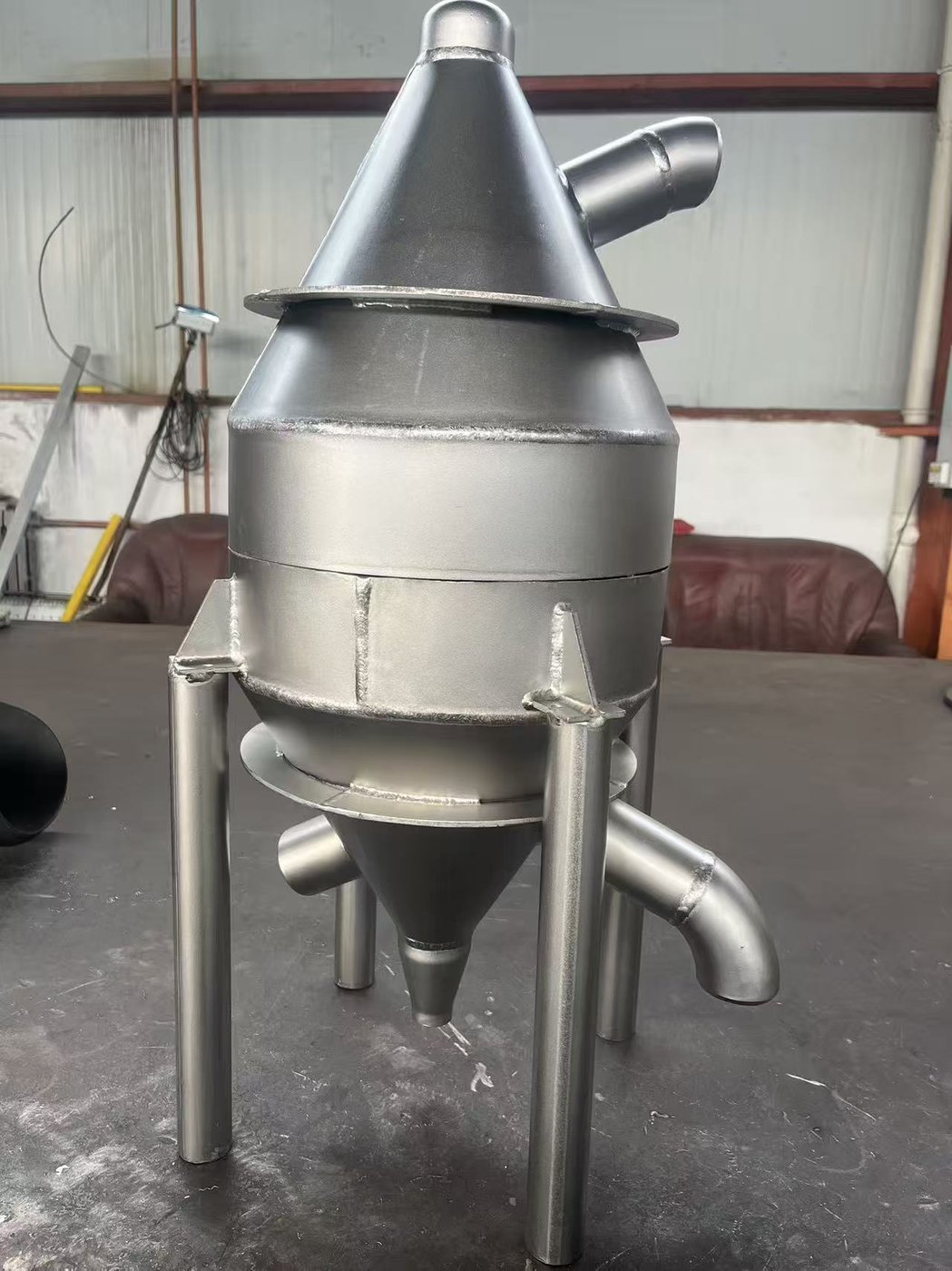 Conical stainless vessel on its support legs